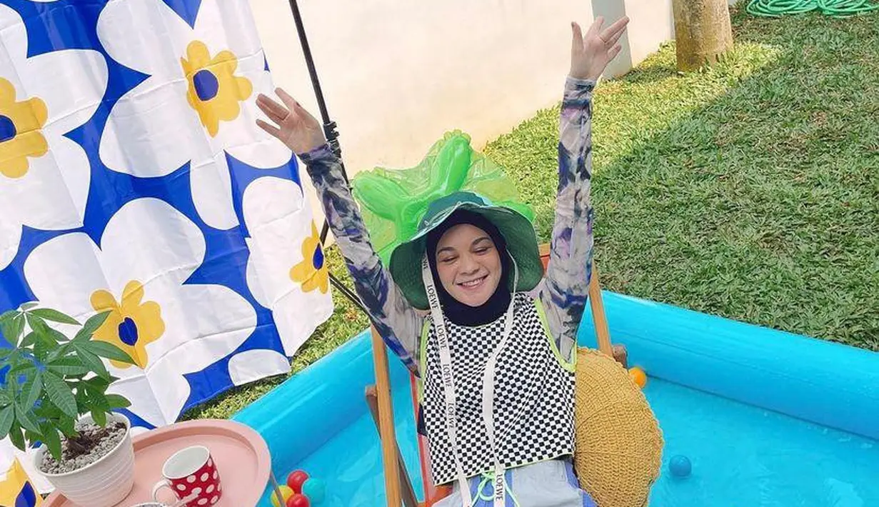 Atur halaman rumahmu seperti layaknya tengah berlibur ke Bali. Tambahkan dekorasi seperti kolam portable hingga kursi santai. [Foto: IG/tantrinamirah].