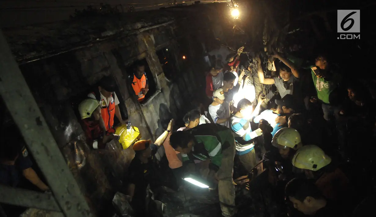 Proses evakuasi korban yang menghimpit korban kecelakaan kereta api di perlintasan Kramat, Senen, Jakarta, Selasa (13/6). Petugas menemukan dua orang yang tewas terbakar. (Liputan6.com/Helmi Afandi)