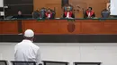 Terdakwa kasus penembakan dr Letty Sultri, dr Helmi mendengarkan dakwaan yang dibacakan oleh JPU di PN Jakarta Timur, Kamis (29/3). Helmi didakwa telah menembak istrinya hingga tewas pada 9 November 2017. (Liputan6.com/Herman Zakharia)
