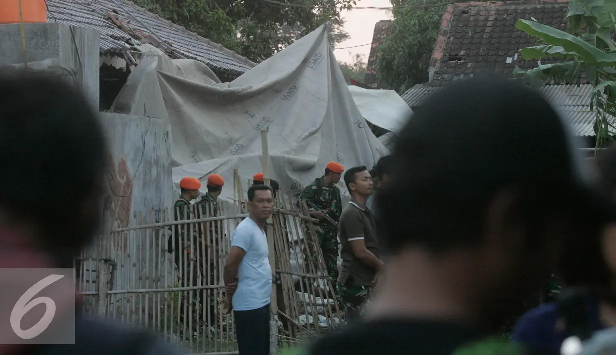 Sejumlah personel TNI AU berjaga di lokasi helikopter jatuh yang sudah di tutup terpal di Dusun Kowang, Sleman (8/7). Heli jatuh setelah melakukan penerbangan dari Solo menuju Yogyakarta. (Liputan6.com/Boy Harjanto)