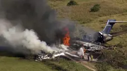 Petugas pemadam kebakaran berusaha memadamkan pesawat yang terbakar setelah gagal lepas landas dari Bandara Eksekutif Houston terlihat di Brookshire, Texas, Amerika Serikat, Selasa (19/10/2021). Seluruh 18 penumpang dan tiga kru selamat. (KTRK via AP)