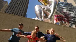 Pengunjung berpose di dekat balon penari balet karya seniman Jeff Koons, di Rockefeller Center, New York City, AS, Jumat (12/5). Keberadaan balon penari balet menjadi ajang foto pengunjung Rockefeller Center. (Spencer Platt / Getty Images / AFP)