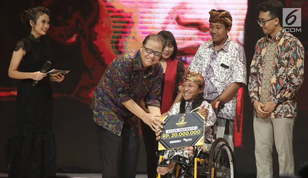 Menteri Koperasi dan UKM Anak Agung Gede Ngurah Puspayoga memberikan piala kepada Ketut Budiarsa dalam Kategori Pemberdayaan Masyarakat saat ajang Liputan6 Awards 2018 di SCTV Tower, Jakarta, Minggu (20/5). (Liputan6.com/Herman Zakharia)