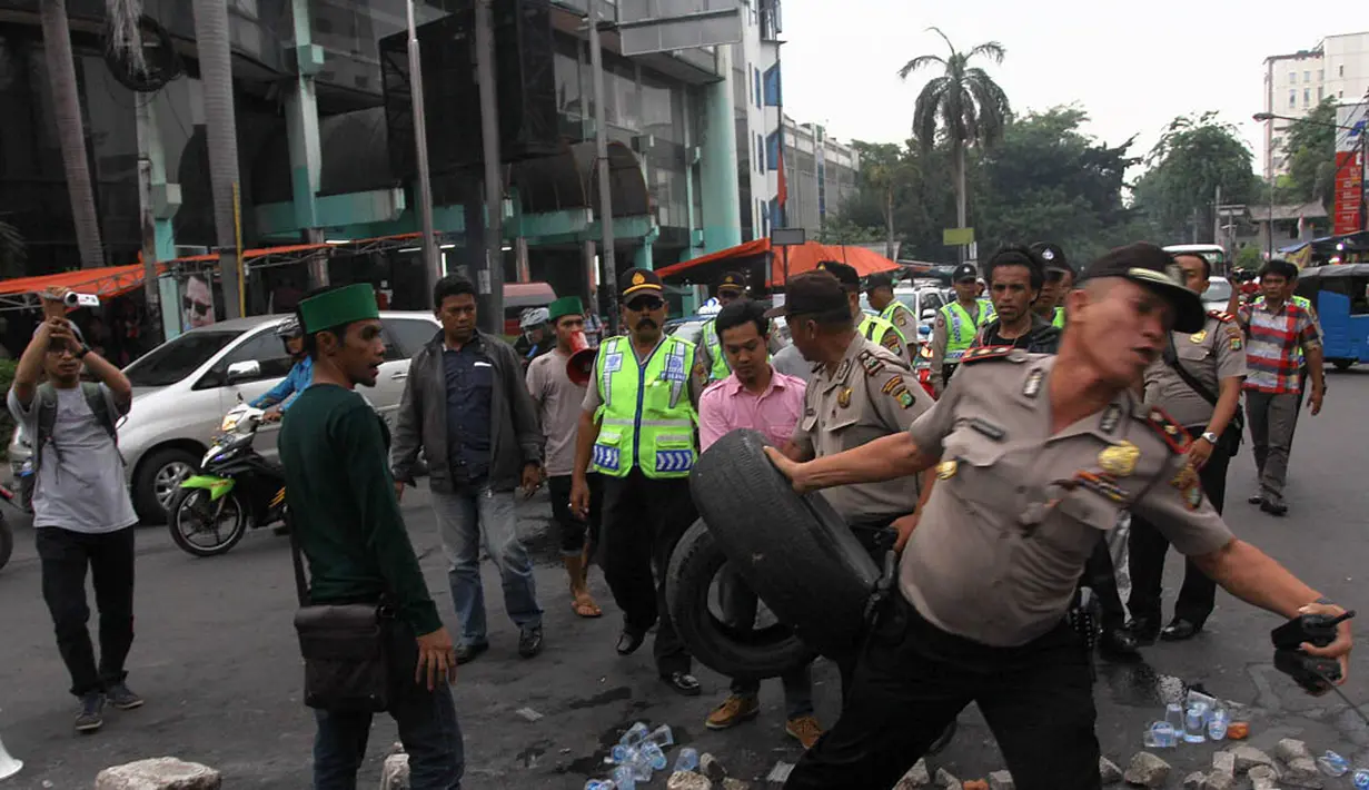 Petugas kepolisian saat mencoba membubarkan aksi para mahasiswa di Jalan Cikini Raya, Jakarta, Selasa (18/11/2014). (Liputan6.com/Faizal Fanani)