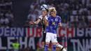 Pemain Timnas Jepang, Junya Ito (kanan), melakukan duel udara dengan pemain Timnas Jerman, Robin Gosens, dalam pertandingan persahabatan yang berlangsung di Volkswagen Arena, Wolfsburg, Minggu (10/9/2023). (AFP/Ronny Hartmann)