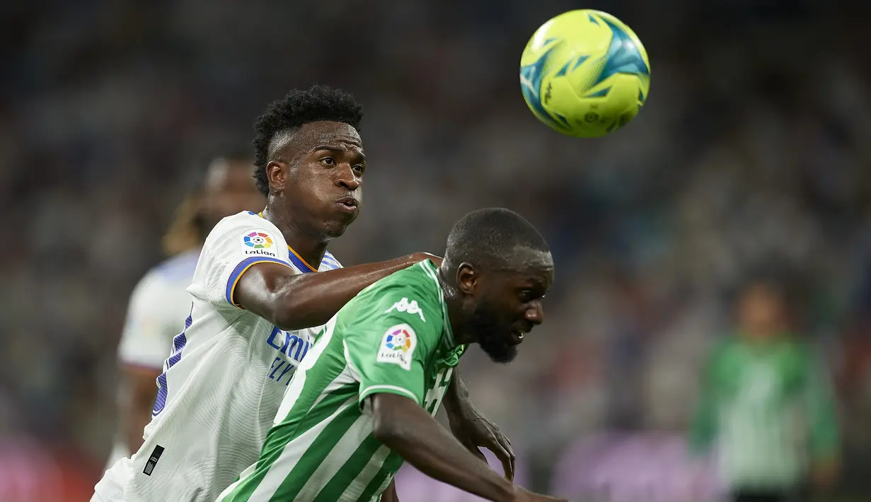 Penyerang Real Madrid, Vinicius Junior berebut bola dengan pemain Real Betis, Youssouf Sabaly pada pertandingan laga terakhir La Liga Spanyol di stadion Santiago Bernabeu di Madrid, Spanyol, Sabtu (21/5/2022). Real Madrid menutup laga La Liga Spanyol musim ini dengan hasil imbang 0-0 melawan Real Betis. (AP Photo/Jose Breton)