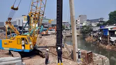 Pekerja dengan menggunakan alat berat memasang turap di Kali Ciliwung, Jakarta, Rabu (3/9/14). (Liputan6.com/Miftahul Hayat)