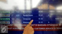 Seorang calon penumpang menunjuk pembatalan penerbangan tujuan Denpasar di Bandara Soekarno Hatta, Tangerang, Jumat (10/7/2015). Puluhan jadwal penerbangan dibatalkan karena erupsi Gunung Raung.  (Liputan6.com/JohanTallo)