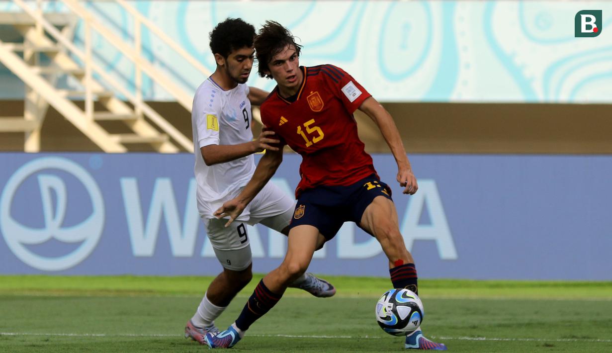 Bek Timnas Spanyol U-17, Andres Cuenca (kanan), mengontrol bola dibayangi pemain Timnas Uzbekistan U-17, Amirbek Saidov dalam laga pamungkas Grup B Piala Dunia U-17 2023 yang berlangsung di Stadion Manahan, Solo, Kamis (16/11/2023) sore WIB. (Bola.com/Arief Bagus Prasetiyo)