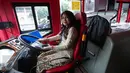 Seorang pramudi bus tingkat wisata TransJakarta mengenakan kebaya saat mengendarai bus tersebut di Jakarta, Jumat (21/4). Dalam rangka Hari Kartini, semua pramudi perempuan bus pariwisata dan Transjakarta mengenakan kebaya. (Liputan6.com/Faizal Fanani)