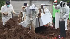 Petugas membawa peti berisi jenazah dengan protokol COVID-19 di TPU Srengseng Sawah, Jakarta, Kamis (21/1/2021). Sebagian lahan TPU Srengseng Sawah yang dijadikan lokasi pemakaman jenazah Covid-19 sejak Selasa (12/1) lalu, kini hanya tersisa 79 petak makam. (Liputan6.com/Helmi Fithriansyah)