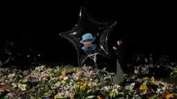 Foto Ratu Elizabeth II ditempatkan di dalam balon saat orang-orang membawa karangan bunga di Green Park London, Senin (12/9/2022). Ratu Elizabeth II meninggal pada usia 96 tahun di Kastil Balmoral, Skotlandia.  Dia adalah penguasa terlama sepanjang sejarah Britania Raya yaitu 70 tahun 214 hari. (AP Photo/Andreea Alexandru)