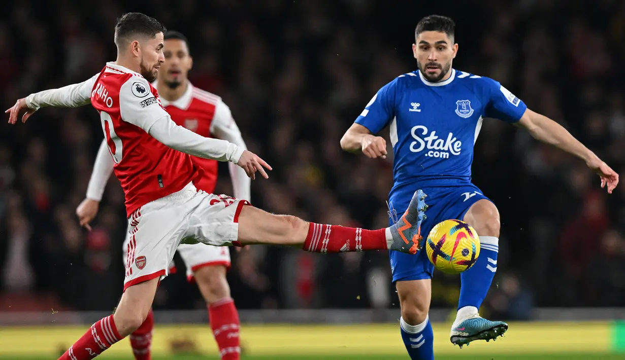 Gelandang Arsenal  Jorginho (kiri) bersaing dengan striker EvertonNeal Maupay pada laga tunda pekan ke-7 Liga Inggris 2022/2023 di Emirates Stadium, Kamis (2/3/2023) dini hari WIB. Dengan kemenangan ini Arsenal menuntaskan dendam melawan Everton setelah pada pertemuan pertama kalah 0-1. (Glyn KIRK / AFP)