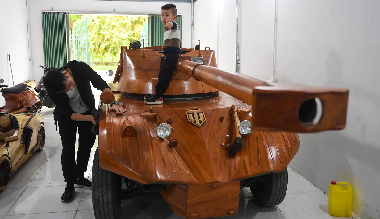 Truong Van Dao membersihkan tank kayunya di bengkelnya di provinsi Bac Ninh, Vietnam pada 28 Maret 2022. Kendaraan kayu, berdasarkan model EBR105 Prancis dan lengkap dengan meriam replika sepanjang 2,8 meter itu, menghabiskan dana USD11 ribu atau sekitar Rp158 juta. (Nhac NGUYEN /AFP)