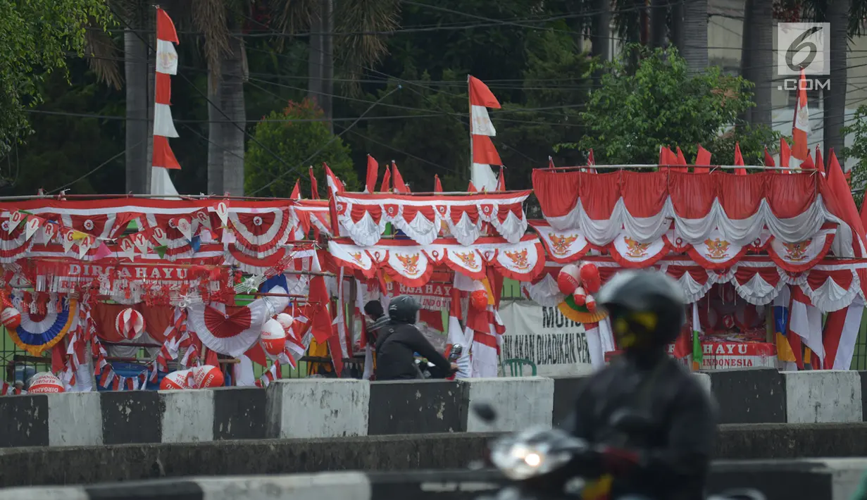 Pengendara motor melintasi pedagang bendera di kawasan Pasar Jatinegara, Jakarta, Rabu (14/8/2019). Pedagang musiman memajang beragam jenis aksesoris seperti bendera merah putih, umbul-umbul dan lambang Garuda untuk perayaan HUT ke-74 RI pada 17 Agustus 2019 mendatang. (merdeka.com/imam buhori)