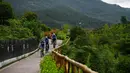 Sejumlah orang bersepeda di sepanjang jalur sepeda di Desa Sanliya di Wilayah Pingli, Provinsi Shaanxi, China barat laut (23/7/2020). Jalur sepanjang 40 kilometer yang membentang di alam bebas ini menawarkan pengalaman yang menyenangkan bagi pesepeda. (Xinhua/Zhang Bowen)