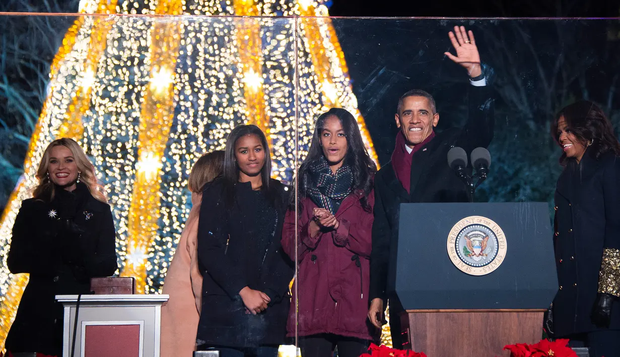 Presiden AS Barack Obama (kedua kanan) melambaikan tangan ke ribuan warga saat akan menyalakan Pohon Natal Nasional di Taman Ellipse, dekat Gedung Putih, Washington, Kamis (3/12). Acara tersebut menandai dimulainya musim Natal. (AFP PHOTO/JIM WATSON)