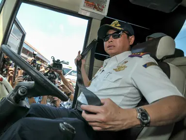 Menteri Perhubungan, Ignasius Jonan memeriksa sabuk pengaman bus pengemudi yang tidak berfungsi, Jakarta, Jumat (24/6). Menhub Jonan tinjau kesiapan Terminal Kampung Rambutan jelang arus mudik. (Liputan6.com/Yoppy Renato)
