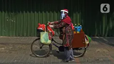 Tidar (46), mengayuh saat berjualan jamu di Pasar Baru, Jakarta, Kamis (11/06/2020). Penjual jamu tradisional keliling ini tampak mematuhi protokol kesehatan pencegahan COVID-19 dengan mengenakan masker, face shield, dan sarung tangan dalam melayani pelanggan setianya. (Liputan6.com/Herman Zakharia)