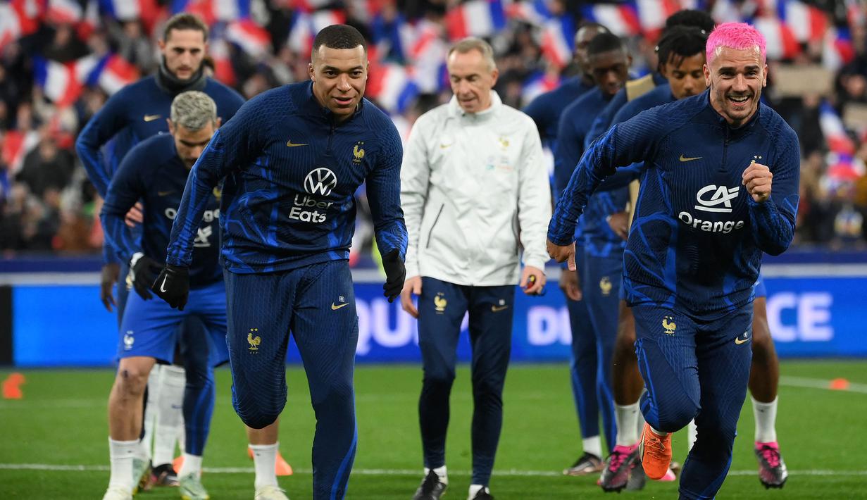 Pemain Timnas Prancis, Kylian Mbappe (kiri) dan Antoine Griezmann melakukan pemanasan sebelum laga Grup B Kualifikasi Euro 2024 melawan Timnas Belanda yang berlangsung di Stade de France, Sabtu (25/03/2023) WIB. (AFP/Franck Fife)