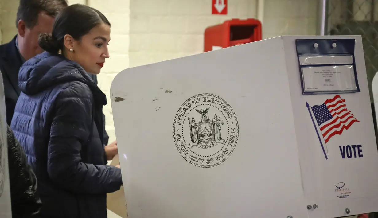 Calon anggota kongres AS Alexandria Ocasio-Cortez masuk ke bilik suara di komunitas Parkchester, Bronx, New York, Selasa (6/11). Berusia 29 tahun, Ocasio-Cortez menjadi perempuan termuda yang terpilih sebagai anggota kongres AS. (AP Photo/Bebeto Matthews)