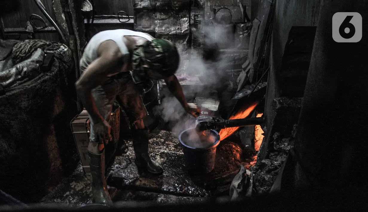 Pekerja saat mengatur api tungku yang menggunakan kayu bakar saat menyelesaikan produksi cincau hitam di industri rumahan kawasan Jatinegara, Jakarta Timur, Rabu (14/4/2021). (merdeka.com/Iqbal S. Nugroho)