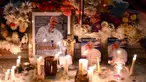 Lilin dan bunga diletakkan di samping foto mendiang Paus Fransiskus di pintu masuk Katedral Buenos Aires, Argentina pada tanggal 21 April 2025. (Luis ROBAYO/AFP)