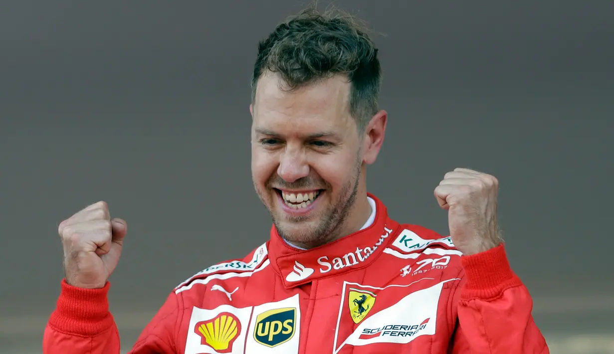 Pembalap Ferrari, Sebastian Vettel bereaksi saat merayakan kemenangannya pada balapan GP Monaco di Sirkuit Monte Carlo, Minggu (28/5). Vettel unggul atas rekan setim Kimi Raikkonen dan penunggang Red Bull Racing, Daniel Ricciardo. (AP Photo/Claude Paris)