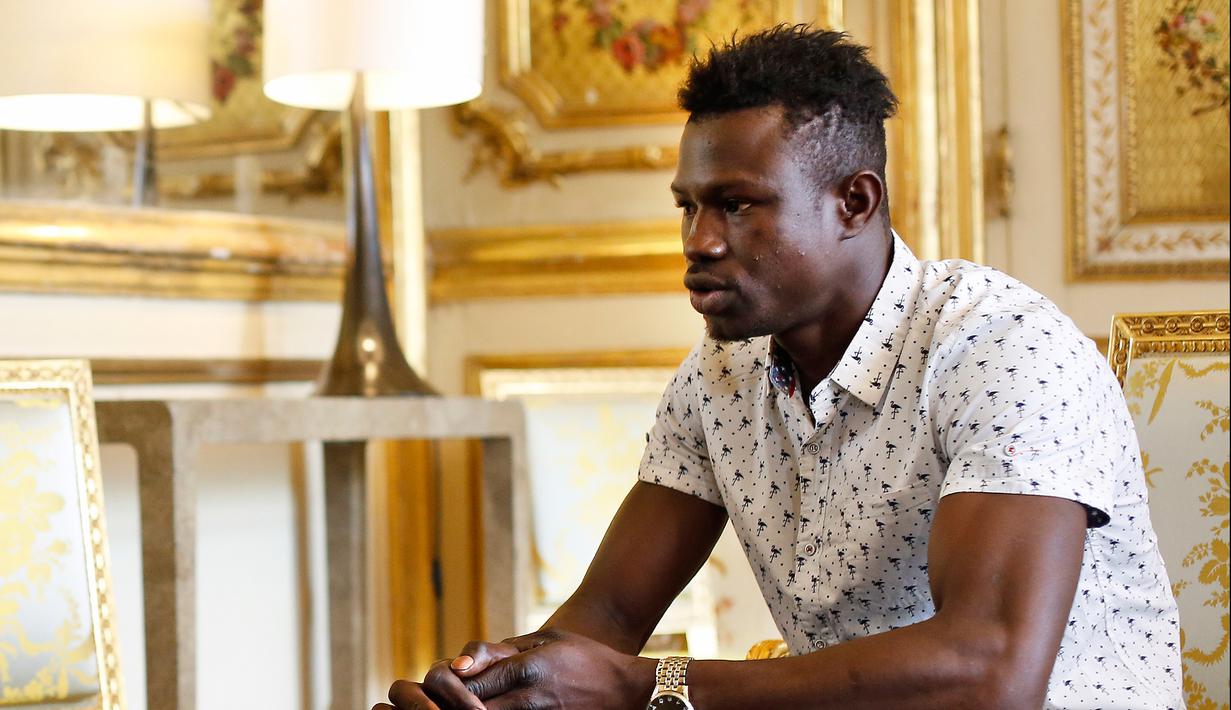 Imigran asal Mali, Mamoudou Gassama saat berbincang dengan Presiden Prancis Emmanuel Macron di Istana Elysee, Paris, Senin (29/5). Selain menawari kewarganegaraan, Macron meminta Gassama bekerja di pemadam kebakaran. (AP Photo/Thibault Camus, Pool)