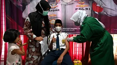 Seorang siswa sekolah menengah pertama menerima dosis vaksin Sinovac pada acara vaksinasi virus corona COVID-19 di Blang Bintang, Provinsi Aceh, 21 September 2021. (CHAIDEER MAHYUDDIN/AFP)