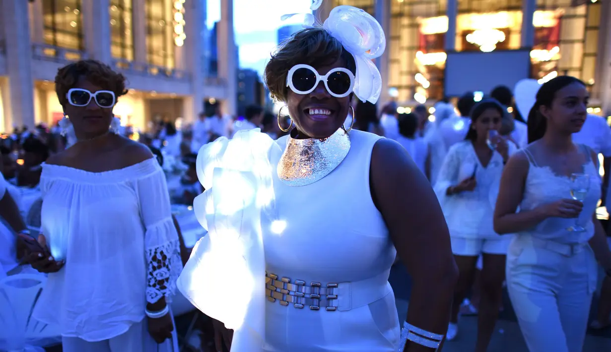 Para tamu menghadiri Diner en blanc (Dinner in White) di alun-alun Lincoln Center, New York, Selasa (22/8). Mereka yang ingin datang ke acara ini, harus menunggu undangan khusus dan pemberitahuan lokasi beberapa menit sebelum acara. (TIMOTHY A. CLARY/AFP)