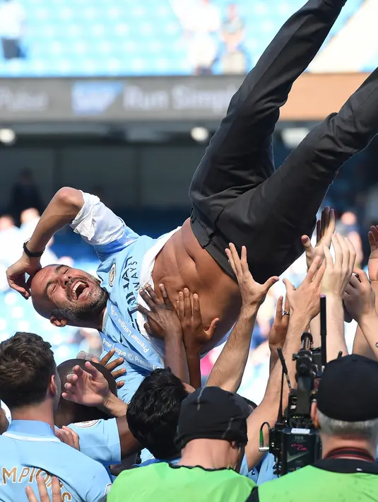 Ekspresi Manajer Manchester City Pep Guardiola saat merayakan gelar juara Liga Inggris di Etihad Stadium (6/5). Manchester City melakukan perayaan tim sebagai juara Liga Inggris 2017-2018 usai bertanding melawan Huddesfiel. (AFP/Paul Ellis)