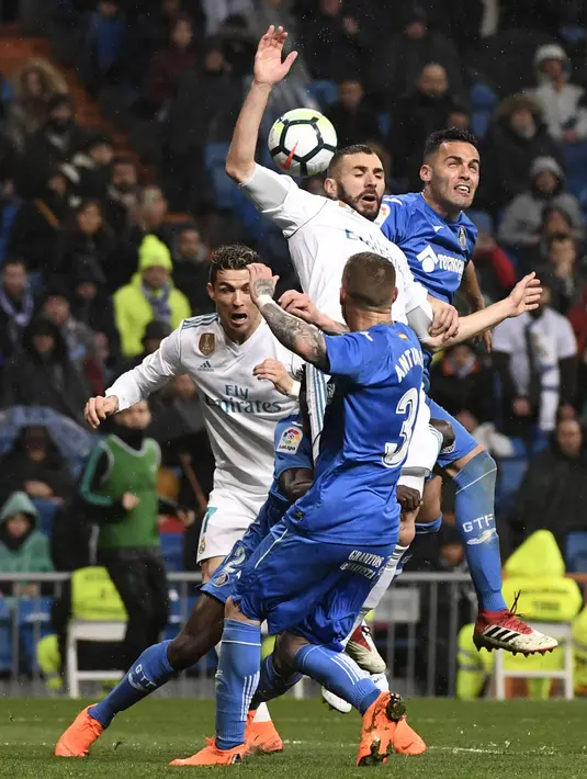 Pemain Real Madrid, Karim Benzema (2kanan) berebut bola dengan pemain Getafe, Bruno Gonzalez (kanan) pada lanjutan La Liga Santander di Santiago Bernabeu stadium, Madrid, (3/3/2018). Real madrid menang 3-1. (AFP/Pierre-Philippe Marcou)