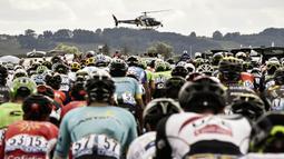 Sebuah Helikopter media melintas didepan pebalap Tour de France pada etape ke-10 antara Perigueux and Bergerac dengan jarak tempuh 178 km, (11/7/2017). (AFP/Jeff Pachoud)