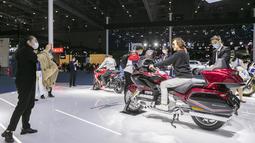 Orang-orang menjajal sepeda motor Honda dalam Pameran Impor Internasional China (China International Import Expo/CIIE) ketiga di Shanghai, China timur (5/11/2020). Total tujuh pabrikan otomotif top dunia berpartisipasi dalam ajang CIIE tahun ini. (Xinhua/Zhao Dingzhe)
