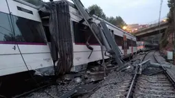 Sebuah kereta komuter yang tergelincir dan keluar jalur  akibat terjangan longsor di Vacarisses, Barcelona, Selasa (20/11). Diketahui ada sekitar 150 penumpang di dalam kereta saat kecelakaan tersebut. (Anti-radar Catalunya via AP)
