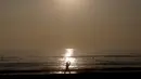 Seorang pria melakukan pemanasan sebelum berselancar di sebuah pantai di La Serena, Chile, Selasa (23/5/2015). (REUTERS/Marcos Brindicci)