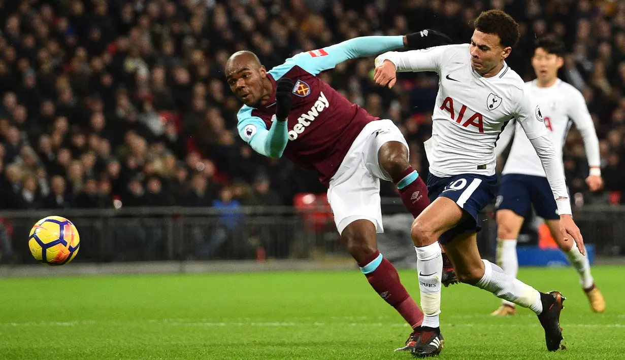 Bek West Ham United, Angelo Ogbonna berebut bola dengan pemain Tottenham Hotspur, Dele Alli dalam pertandingan Premier League di Stadion Wembley, Jumat (5/1). Tottenham Hotspur harus puas bermain imbang 1-1 saat menjamu West Ham. (Glyn KIRK / AFP)