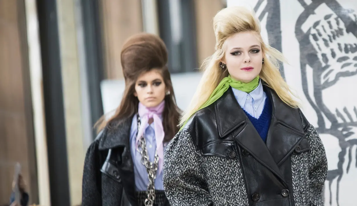 Aktris Elle Fanning membawakan busana karya Miu Miu pada pagelaran Paris Fashion Week Fall-Winter 2018, Selasa (6/3). Elle tampil berjalan menyusuri panggung tepat di depan super model Kaia Gerber. (Vianney Le Caer/Invision/AP)