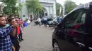 Sejumlah orang mengambil gambar mobil yang membawa mantan pesepakbola David Beckham meninggalkan SMPN 17 Semarang, Jawa Tengah, Rabu (28/3). Sempat dirahasiakan, kedatangan David Beckham ke Semarang menjadi perhatian masyarakat. (Liputan6.com/Gholib)