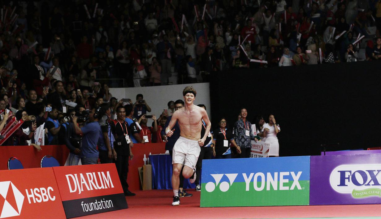 Pebulutangkis Denmark, Anders Antonsen, melakukan selebrasi buka baju usai mengalahkan wakil Jepang, Kento Momota, pada laga Indonesia Masters 2019 di Istora, Jakarta, Minggu (27/1). Antonsen menang 21-16, 14-21, 21-16. (Bola.com/M Iqbal Ichsan)