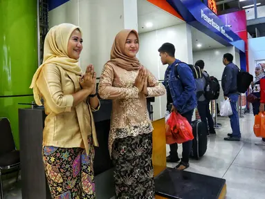 Petugas frontliner berpakaian tradisional menyambut calon penumpang di Stasiun Gambir, Jakarta, Minggu (21/4). PT KAI Daop 1 Jakarta mewajibkan petugas frontliner wanita dan pria mengenakan kebaya dan batik untuk menyambut Hari Kartini. (Liputan6.com/Johan Tallo)