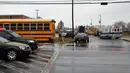 Sejumlah kendaraan dari petugas keamanan dan bus sekolah terparkir di dekat pintu masuk Great Mills High School di Maryland, AS (20/3). Seorang pelaku penembakan bernama Austin Wyatt Rollins melukai dua siswa di sekolah tersebut. (AP Photo / Alex Brandon)