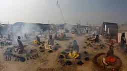 Orang suci Hindu membakar kotoran sapi kering dalam ritual Basant Panchami dalam festival tahunan Magh Mela di Allahabad, India, Senin (22/1). Basant Panchami dilakukan di kawasan Sangam, pertemuan Sungai Gangga dan Yamuna. (AP Photo/Rajesh Kumar Singh)