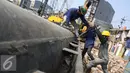 Sejumlah pekerja mengencangkan baut tiang pancang untuk pemasangan turap bantaran Kali Ciliwung, Kampung Pulo, Jakarta (26/8/2015). Pemprov DKI Jakarta menargetkan pemasangan turap selesai dalam waktu tiga bulan. (Liputan6.com/Gempur M Surya)