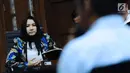Bupati nonaktif Kutai Kartanegara, Rita Widyasari menyimak keterangan saksi pada sidang lanjutan dugaan suap pemberian izin lokasi perkebunan kelapa sawit di Pengadilan Tipikor, Jakarta, Rabu (21/2). (Liputan6.com/Helmi Fithriansyah)