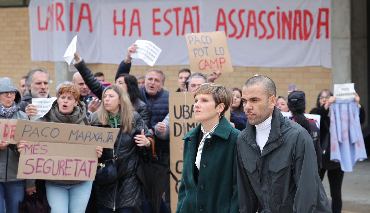 Pemain Brasil, Dani Alves (kanan) bersama pengacaranya, Ines Guardiola berjalan meninggalkan penjara Brians 2 di San Esteban Sasroviras, Barcelona, Spanyol, 25 Maret 2024. Alves bebas dari penjara setelah membayar uang jaminan 1 juta euro ke Pengadilan Barcelona. (AFP/Lluis Gene)