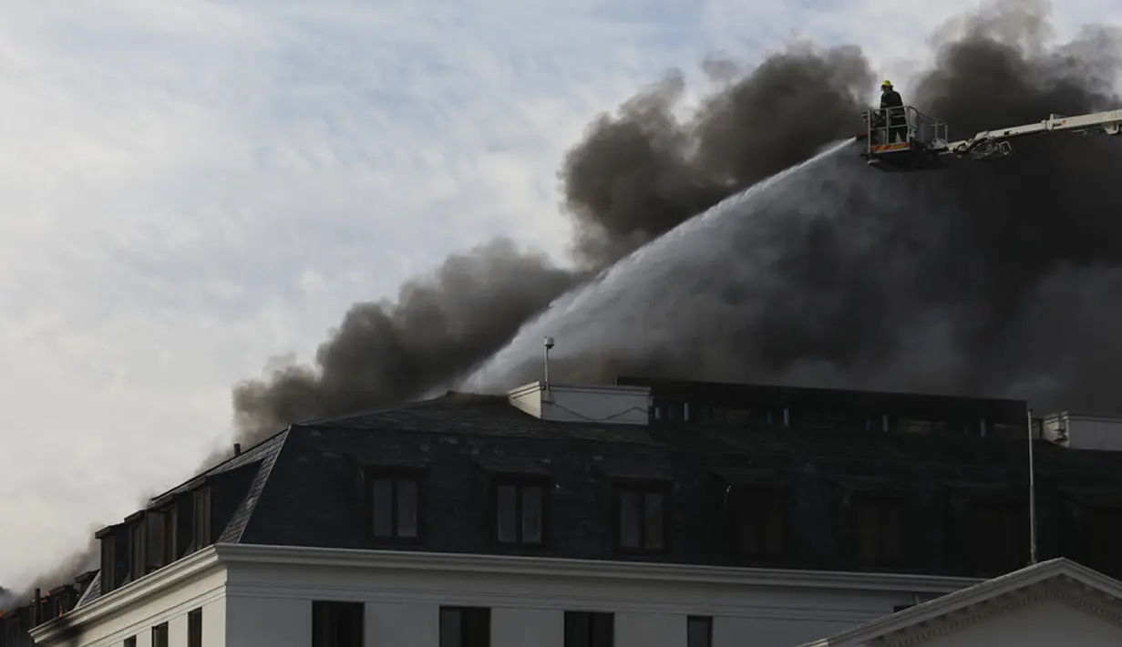 Petugas pemadam kebakaran memadamkan api yang membakar Gedung Parlemen di Cape Town, Afrika Selatan, 3 Januari 2022. Setelah sempat berhasil dipadamkan, api kembali mengamuk dan membakar Gedung Parlemen Afrika Selatan. (AP Photo/Nardus Engelbrecht)