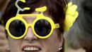 Seorang wanita menggunakan kacamata berbentuk sepeda untuk menyambut lomba balap sepeda Tour de France di Taman Lepelenburg, Utrecht, Belanda. (2/7/2015). (AFP PHOTO/Lionel Bonaventure)