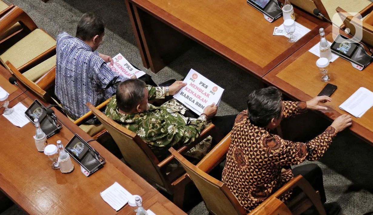 Anggota Fraksi PKS memegang poster bertuliskan “Tolak Kenaikan Harga BBM” saat Rapat Paripurna ke-4 masa persidangan I tahun 2022-2023 di Kompleks Parlemen, Senayan, Jakarta, Selasa (6/9/2022). Fraksi Partai Keadilan Sejahtera (PKS) mengambil sikap walkout dari Rapat Paripurna DPR atas penolakan kenaikan harga bahan bakar minyak (BBM). (Liputan6.com/Angga Yuniar)